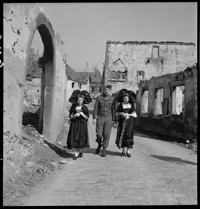 Alsatian Girls [in traditional costume, walking in Ammerschwihr ruins with American officer, Colonel Gerry.]