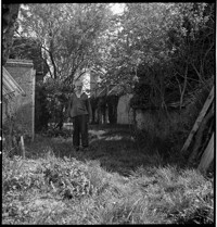 [Artist/sculptor Henri Edouard Navarre outside country cottage and ceramics studio]