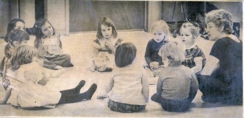 Children and a woman sitting in a circle