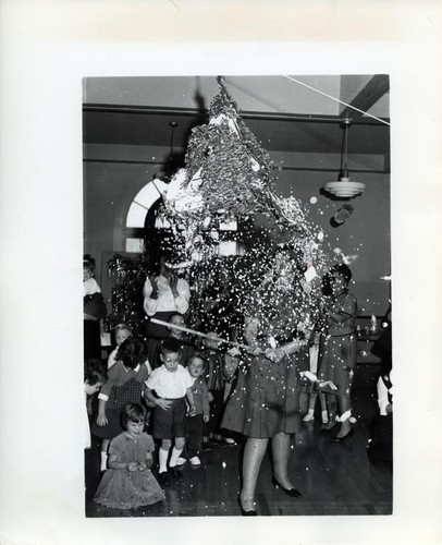 Mrs. Roy Chittick breaks open a pinata