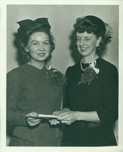 Two women wearing hats and corsages