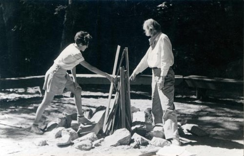 Two female campers building a campfire