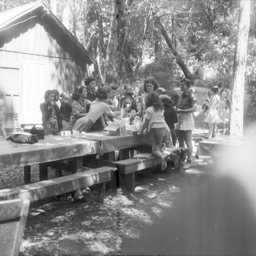 Group of girls of various ages eating at a picnic table