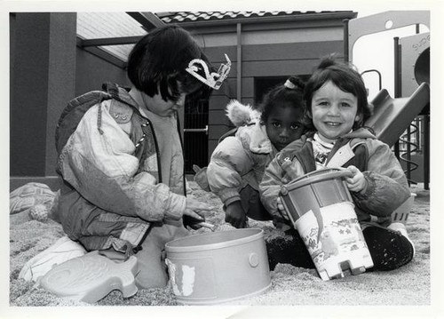 Girls playing in the sand at the child care center