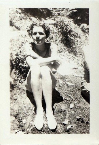 Female camper sitting on the ground outdoors