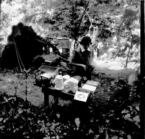 Teenage girl outdoors standing next to a table