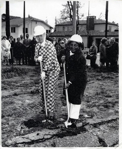 Two women digging with shovels at a groundbreaking ceremony