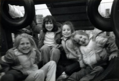 Four girls sitting on a playstructure