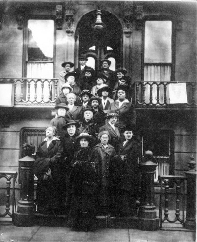 Group of people posing on the steps outside of a building