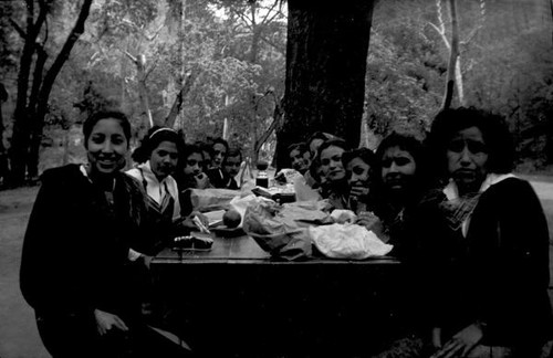 Group of teenage girls eating lunch at a picnic table