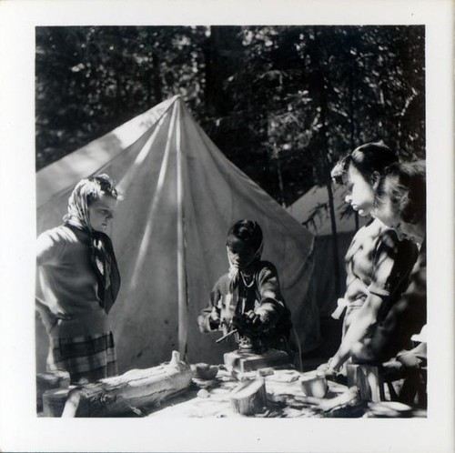 Teenage girls working on a project in a forested area