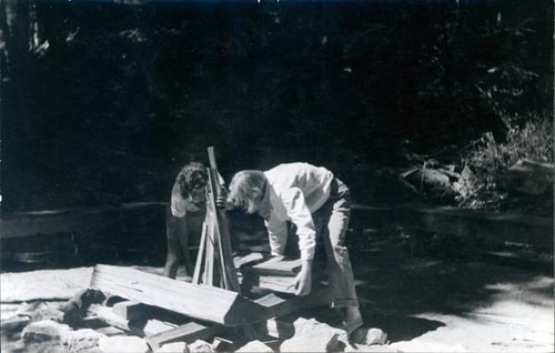 Two female campers building a campfire