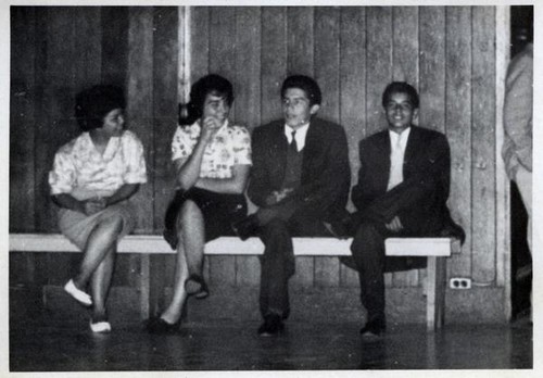 Teenage girls and boys sitting on a bench