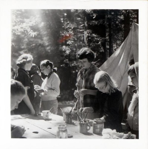 Small group of girls finishing up projects at a picnic table