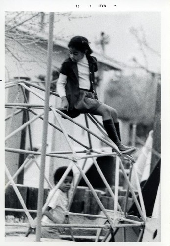 Two girls playing on a jungle gym