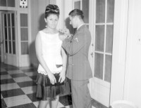 Man pinning a corsage on a woman