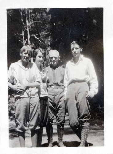 Four people posing in a wooded area