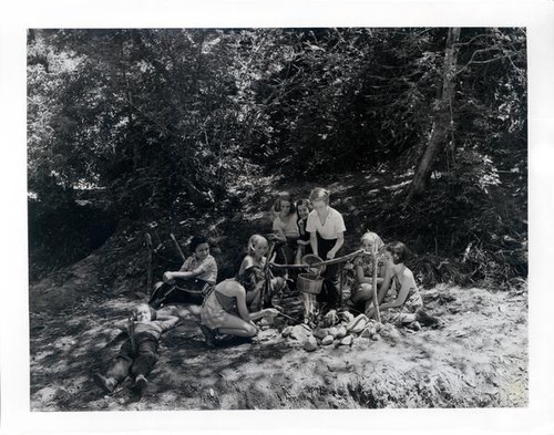 Group of girls cooking over an open campfire