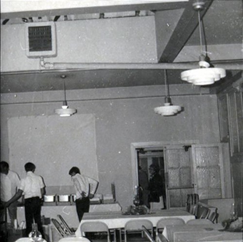 Three young men standing around a table