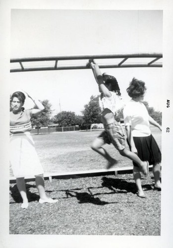 Young girl playing on monkey bars