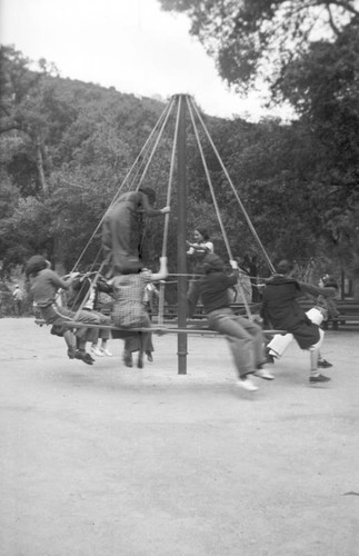 Group of teenage girls playing on a piece of playground equipment