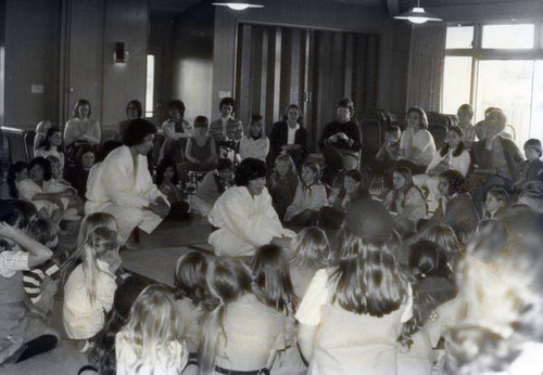 Martial artists speaking to children and adults