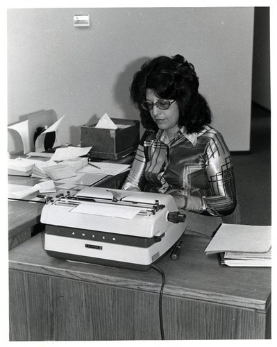 Woman typing on a typewriter