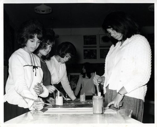 Four teenage girls painting pictures