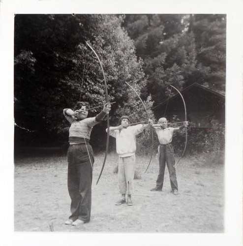 Three girls practicing archery