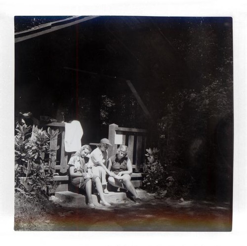 Teenage girls sitting and writing on the steps of a building