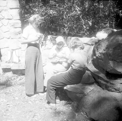 Teenage girls working with their hands at a stone hearth