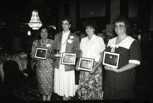 Women posing with plaques