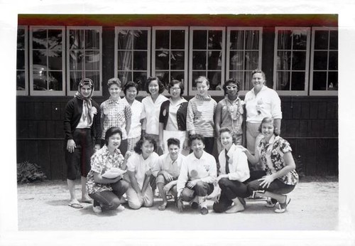 Teenage girls and women posing in front of a building at Asilomar