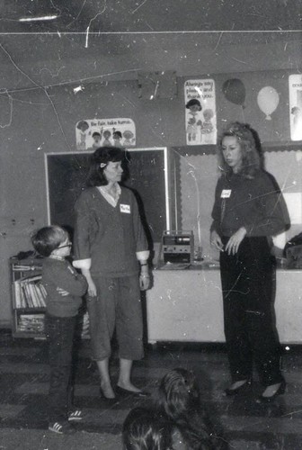 Women and a boy at the front of a classroom