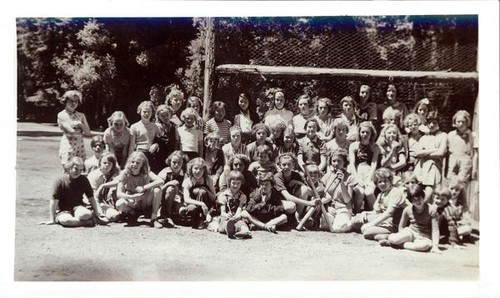 Group of girls posing next to a baseball diamond