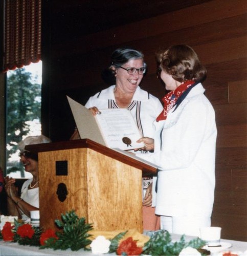 Lois Cullison receives a certificate from Susanne B. Wilson