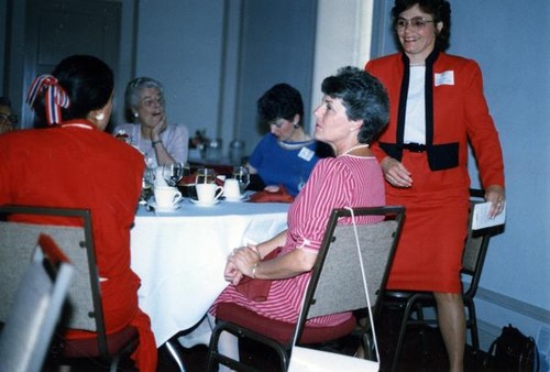 Woman rising from a dining table