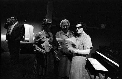 Women looking at a dedication booklet