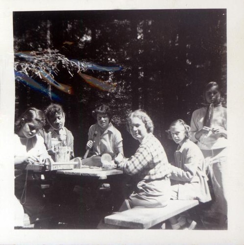 Teenage girls working on a project at a picnic table