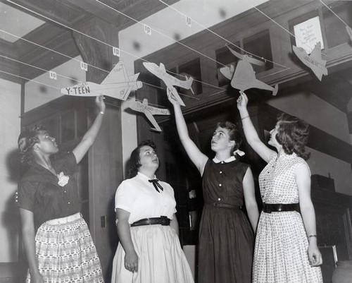 Teenage girls check paper aircraft