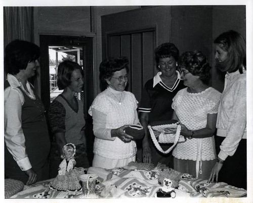 Group of women with crocheted crafts