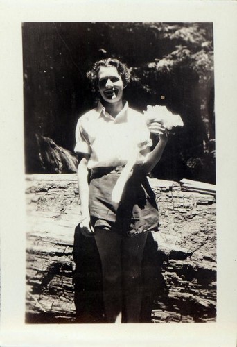 Woman posing in front of a fallen redwood tree