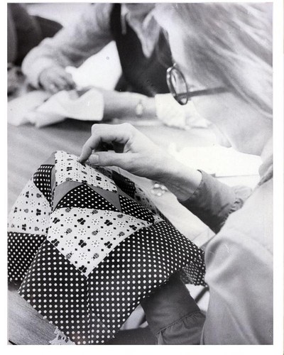 Woman hand sewing a quilt square