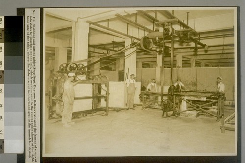 Slabbing and cutting tables Soap Dept. Bayonne Refinery showing the frames of soap cut into slabs by machine on the left, which are then sent to the cutting table shown at the right-hand side of the table, where the slabs are cut into bars and sent to the tunnels for drying