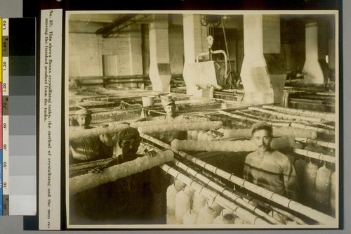 This shows Borax crystallizing tanks, the method of crystallizing and the men removing the finished product from the tanks