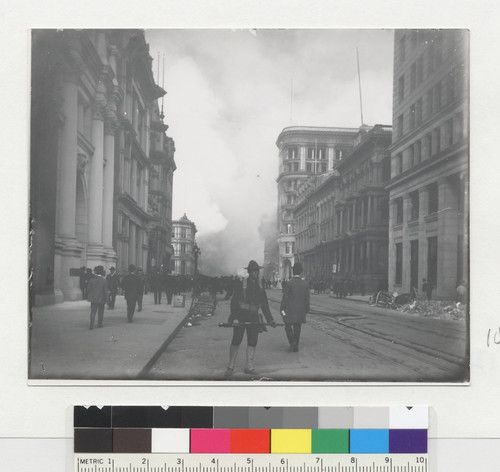 [Soldier patroling California St. View looking east toward fire, with Mutual Life Building at Sansome St., right center.]