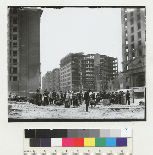 [Crowd searching through rubble. At O'Farrell and Market Sts.? Left to right: Mutual Savings Building, Palace Hotel, Monadnock Building, and Call Building.]