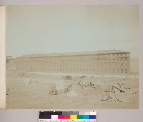 [Fontana and Co. building. Makeshift refugee camp in foreground.]