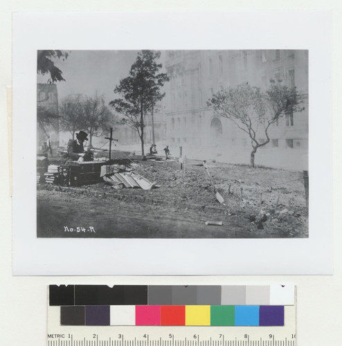 [Writer Henry Lafler at typewriter in Portsmouth Square, adjacent to graves. Hall of Justice in background.]