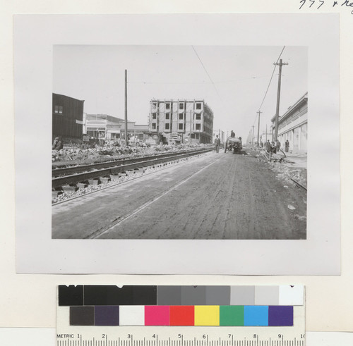 [Street scene during reconstruction showing railroad tracks, new buildings, lumber wagon, etc. Unidentified location.]